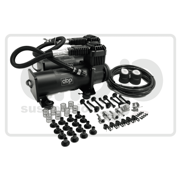 Two black air compressors with "ABP" logos lay on a white surface, surrounded by various parts including springs, bolts, filters, and cables needed for installation and operation.