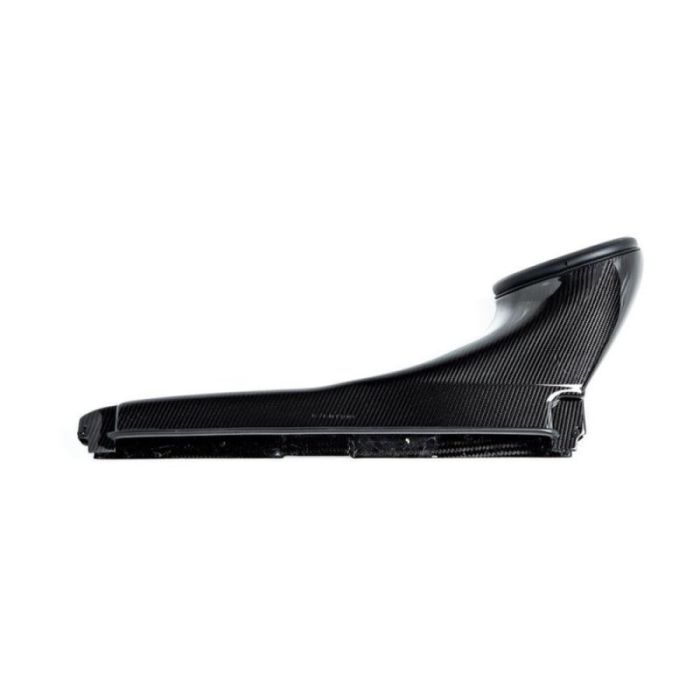 A black carbon fiber air intake duct, ridged and contoured, lies horizontally isolated against a white background. The shape tapers from a wide base to a narrow top.