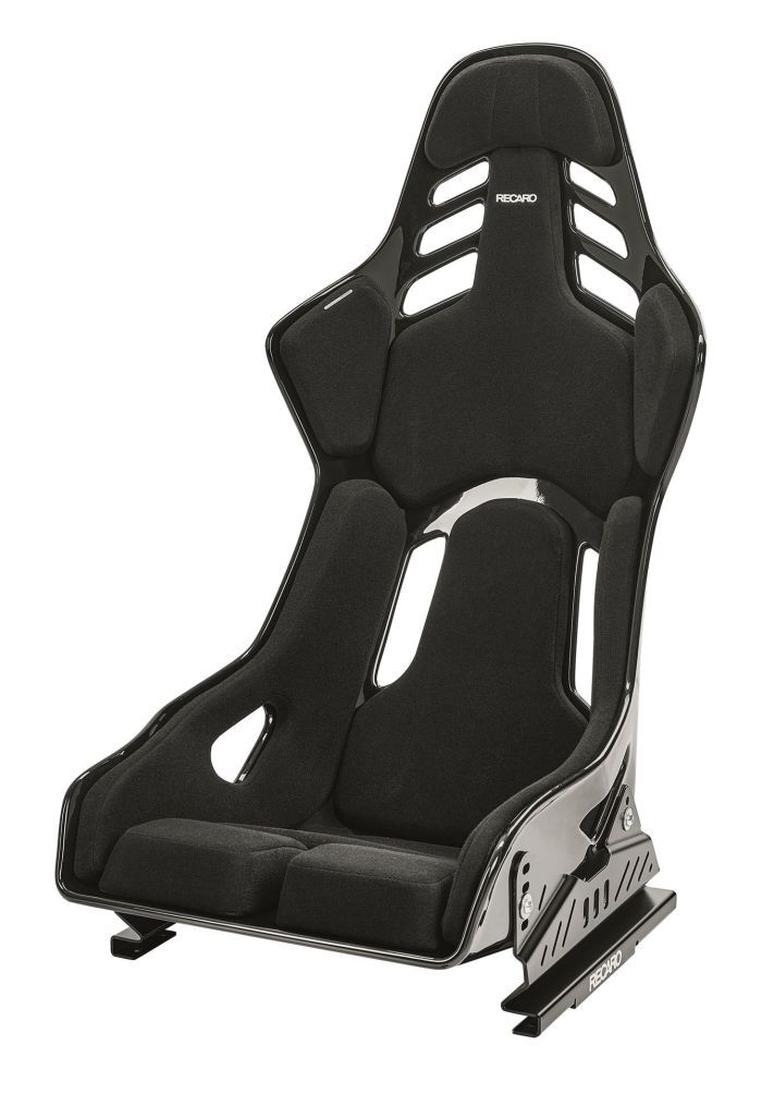 A black racing seat with padded interior and multiple slits designed for harnesses, labeled "RECARO" both on the headrest and base, sits against a plain white background.
